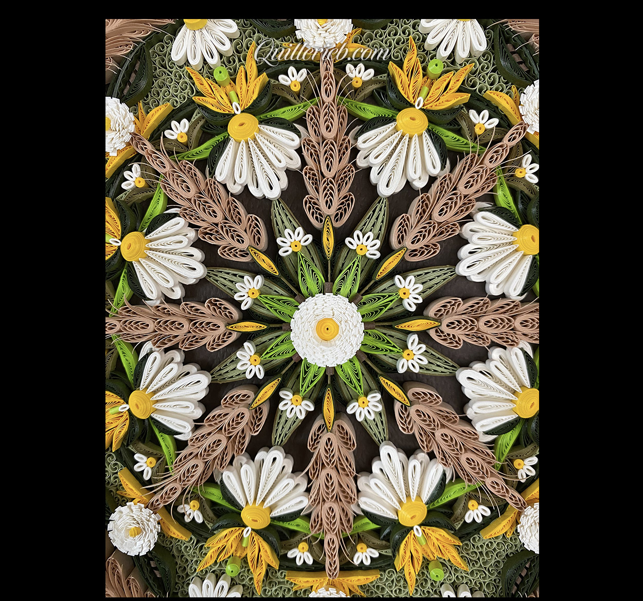 Circular quilling in green, brown, gold and white colors close-up center view.