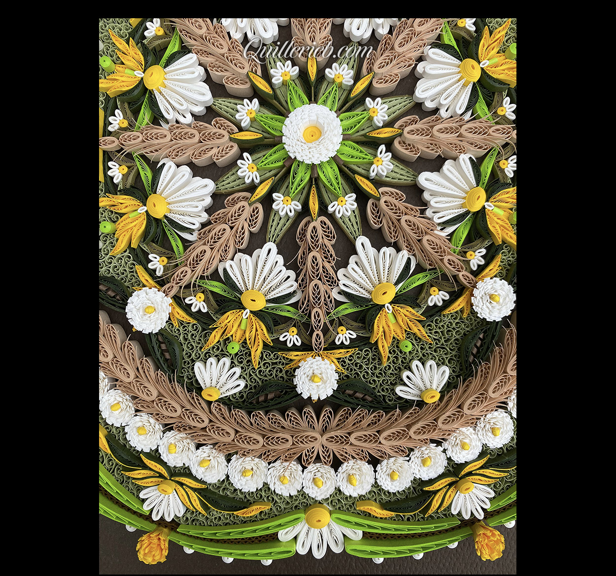 Circular quilling in green, brown, gold and white colors close-up bottom view.