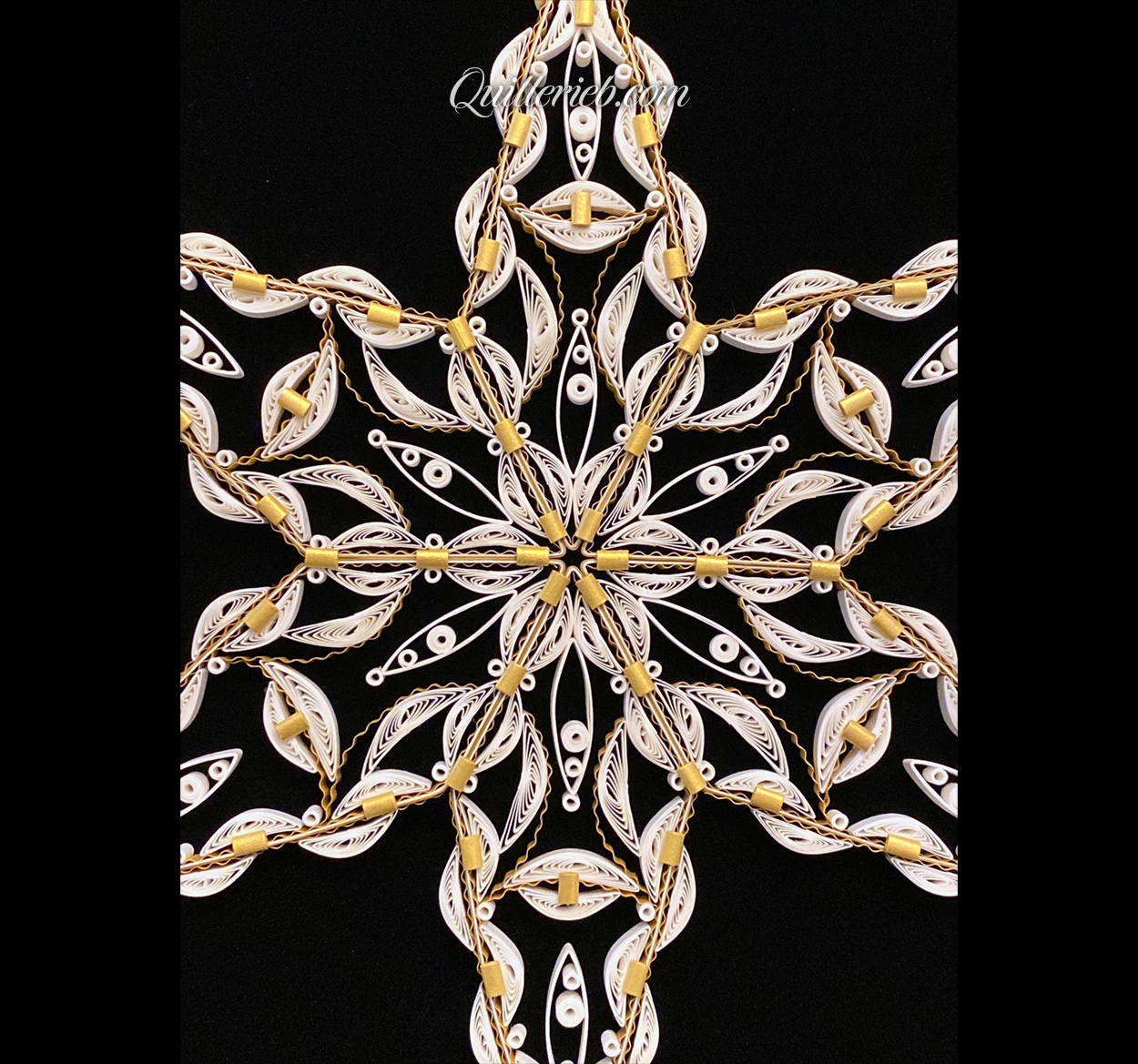 Rounded six-Point Star quilling design in white with elements of gold tones close-up center view.